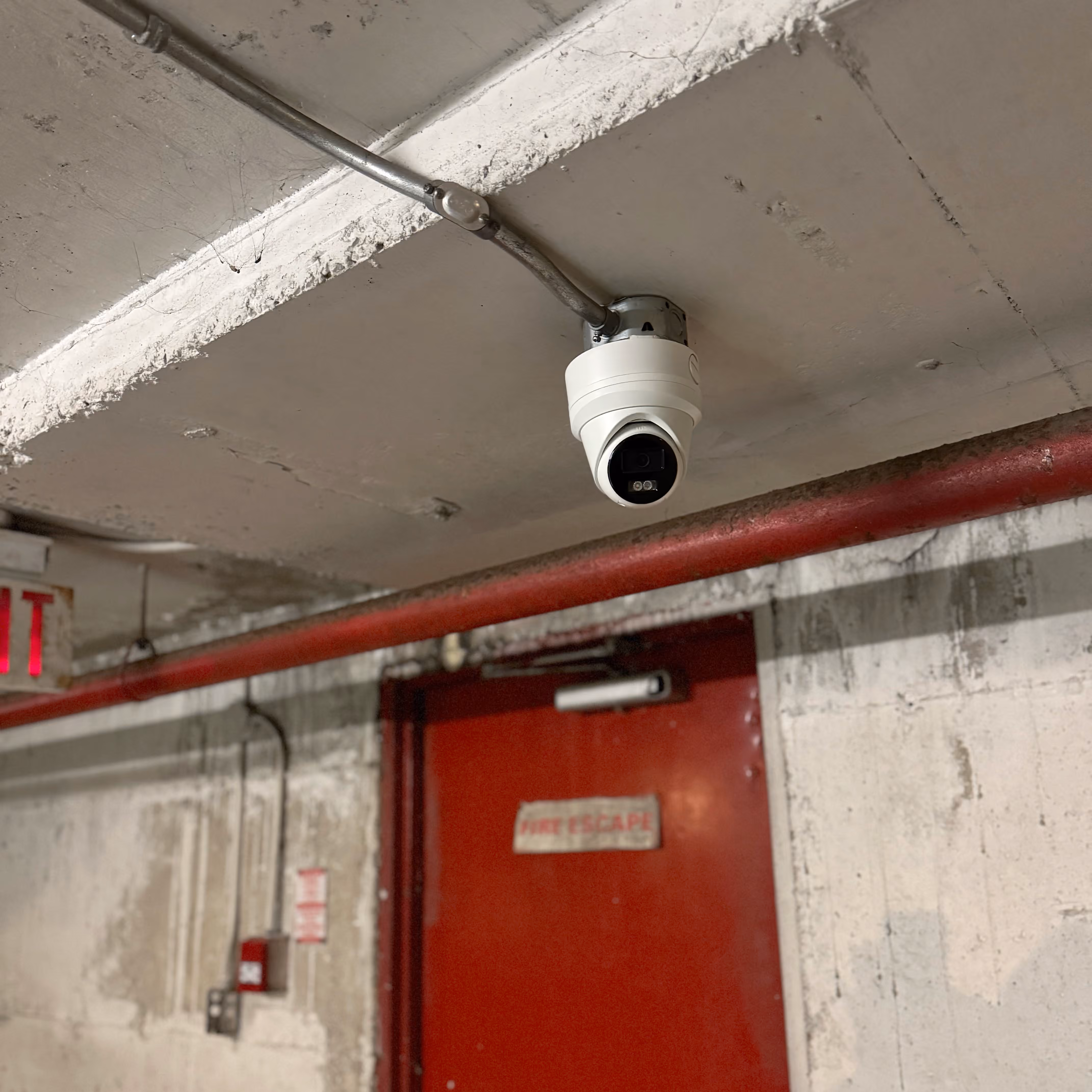 Commercial security camera installed above a parking garage exit