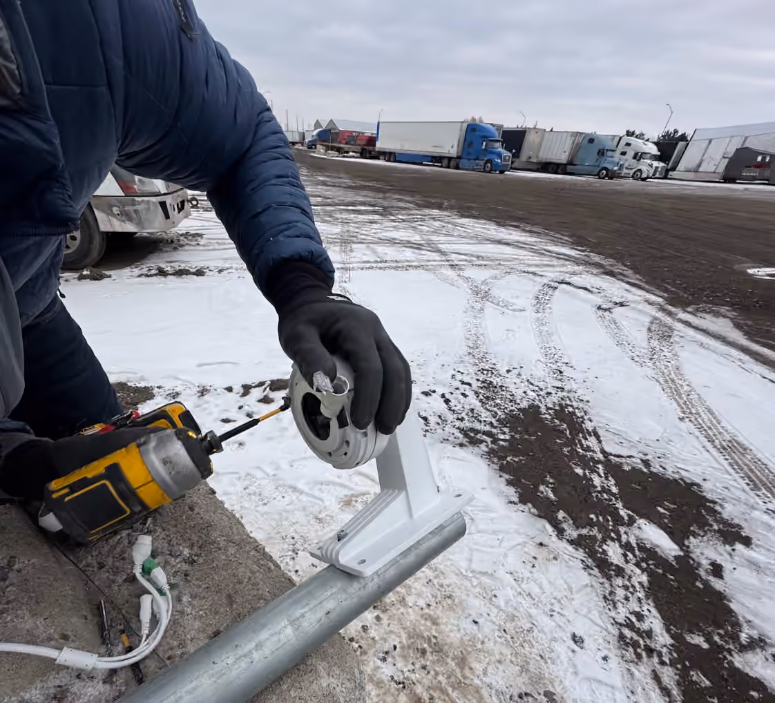 Technician mounting an outdoor commercial security camera