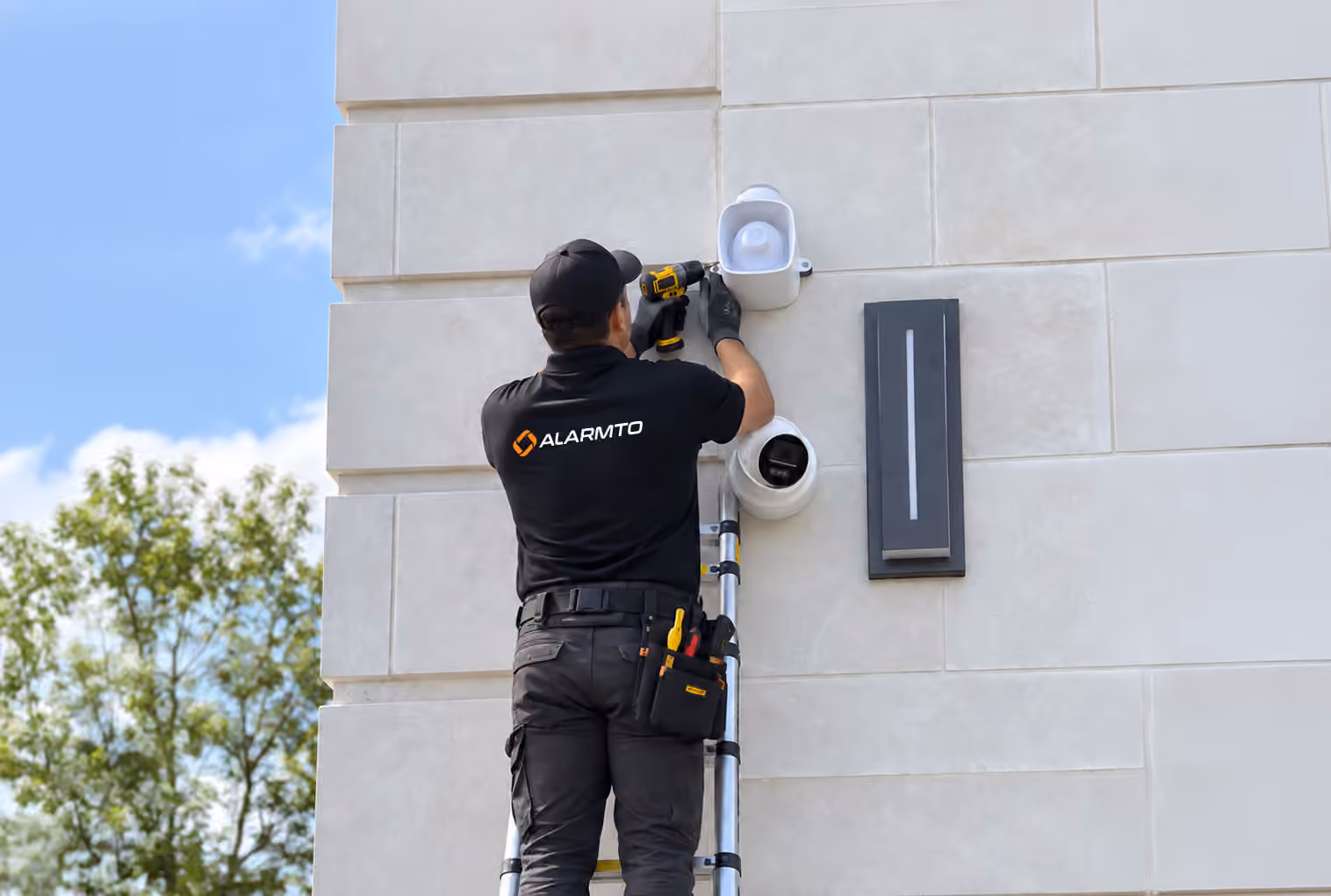Alarmto technician installing a security camera on a home exterior
