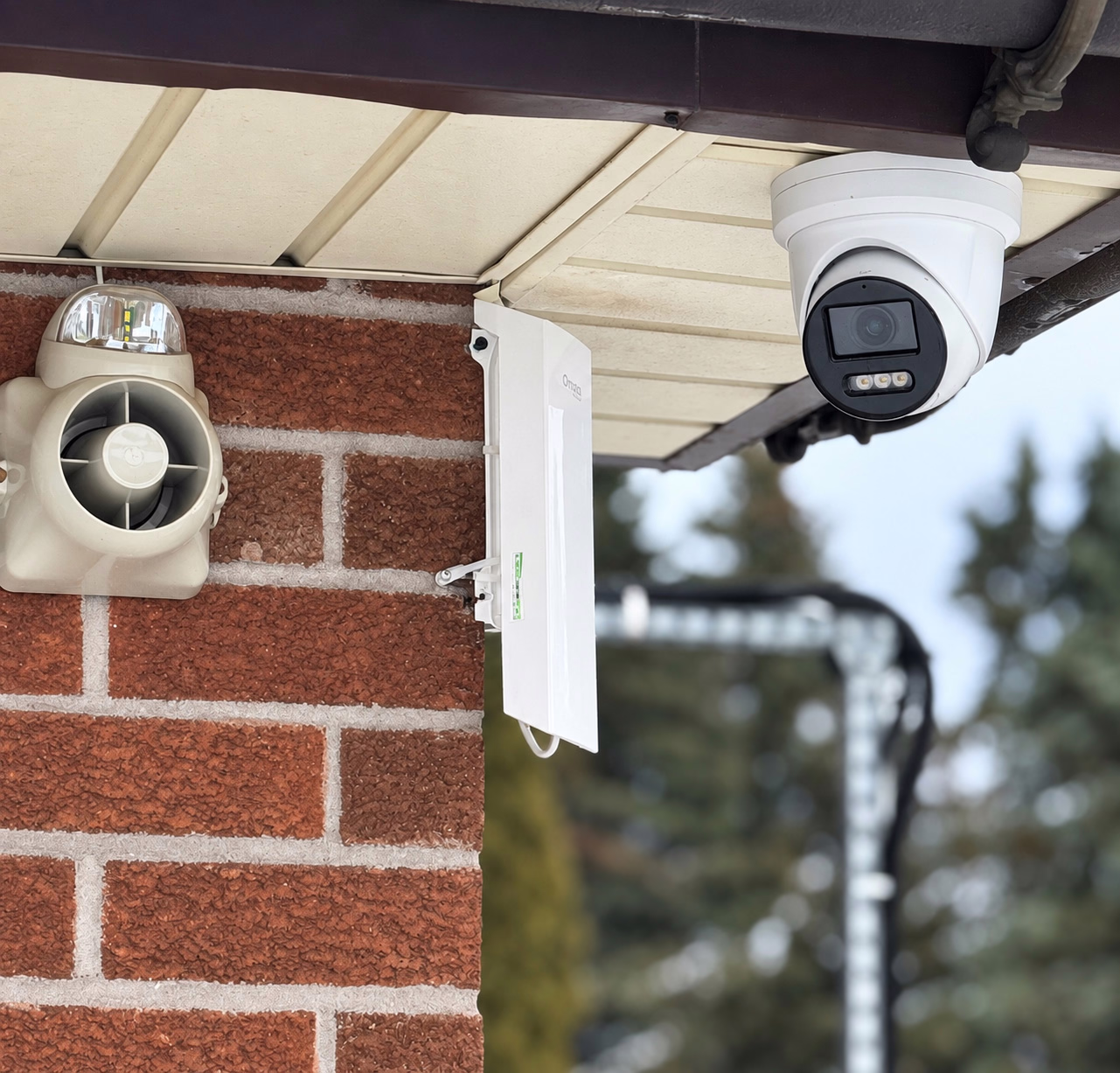 Exterior security camera mounted beneath a roof