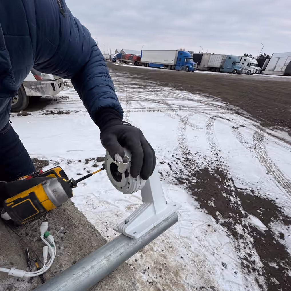 Technician preparing an outdoor security camera installation on a roof