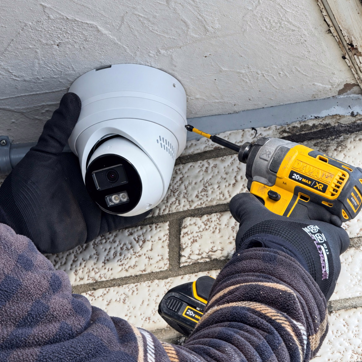 Technician installing an exterior security camera at a Scarborough property