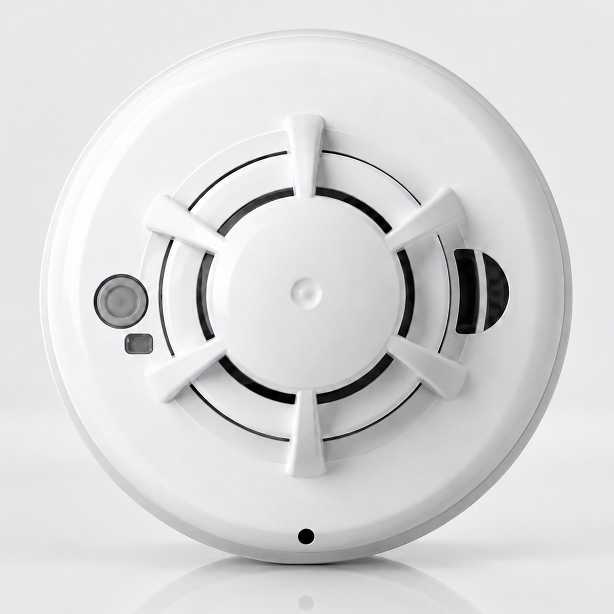 Round white smoke and heat detector with test button